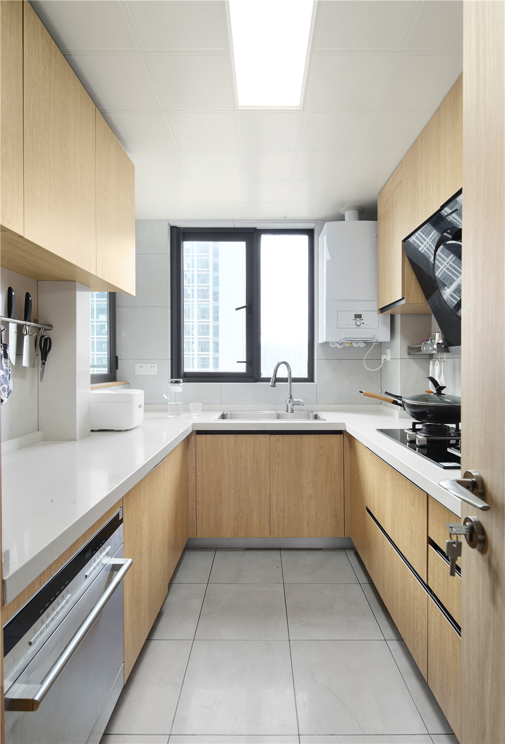 厨房选用原木色搭配白色墙砖，简洁大方，显得空间大！再选择U型设计风格，有效地为小空间做收纳，提高空间利用率。