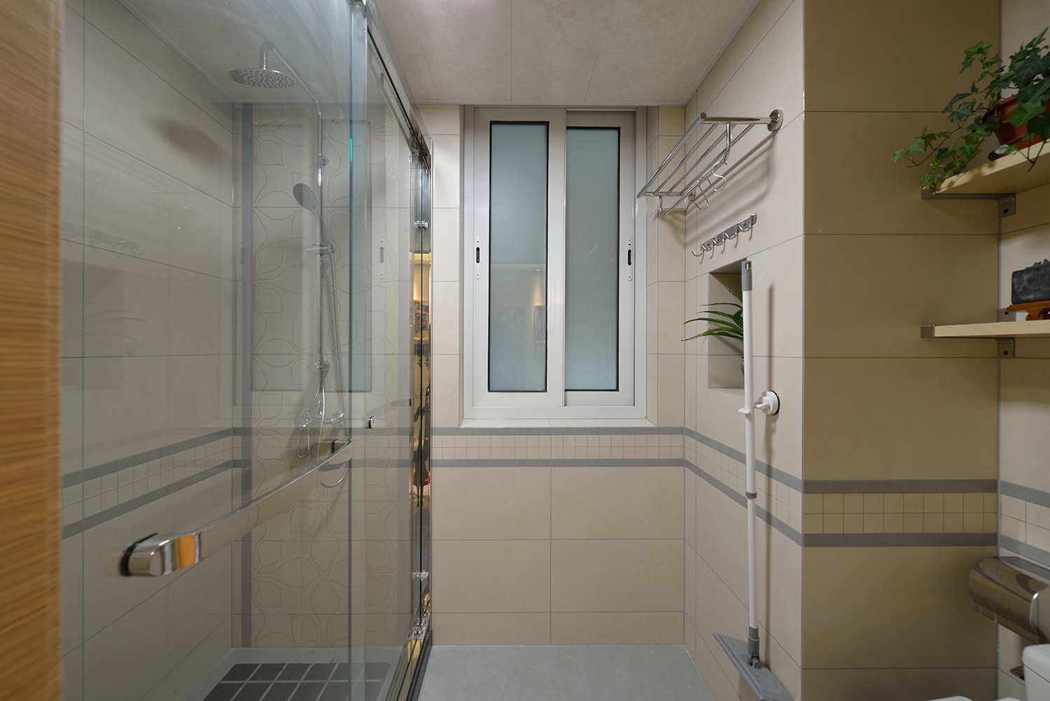 屋主特意选了一款墙面和地面同纹理的瓷砖，这样看起来浴室柜与卫生间更像是一个整体；淋浴区利用包管位置做了一个壁龛，用于放置洗漱用品，比成品的置物架清洁起来也更方便和实用。