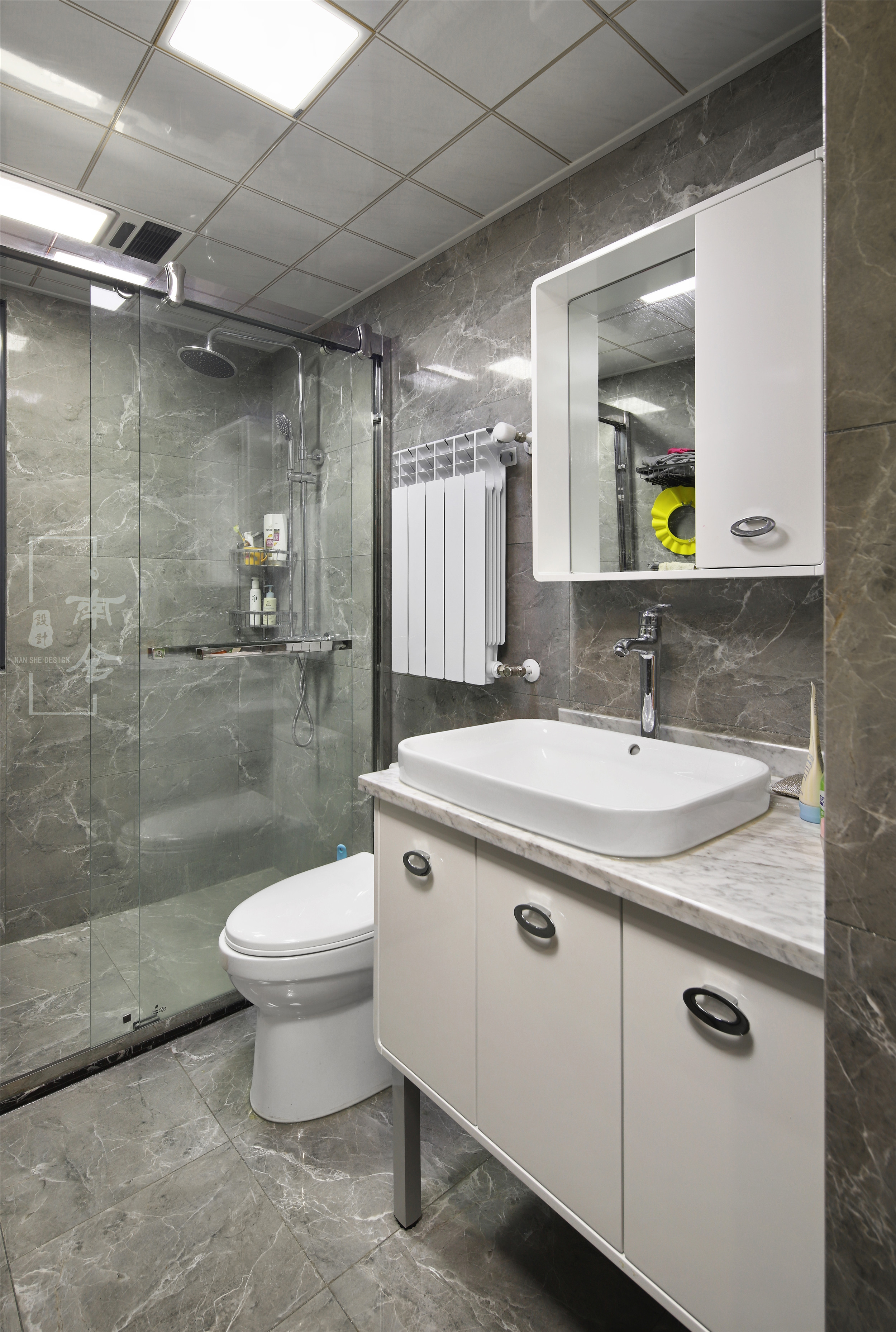 卫生间的墙砖和地砖运用相同的灰色调花纹，光滑的平面更显质感，却又时尚耐看。