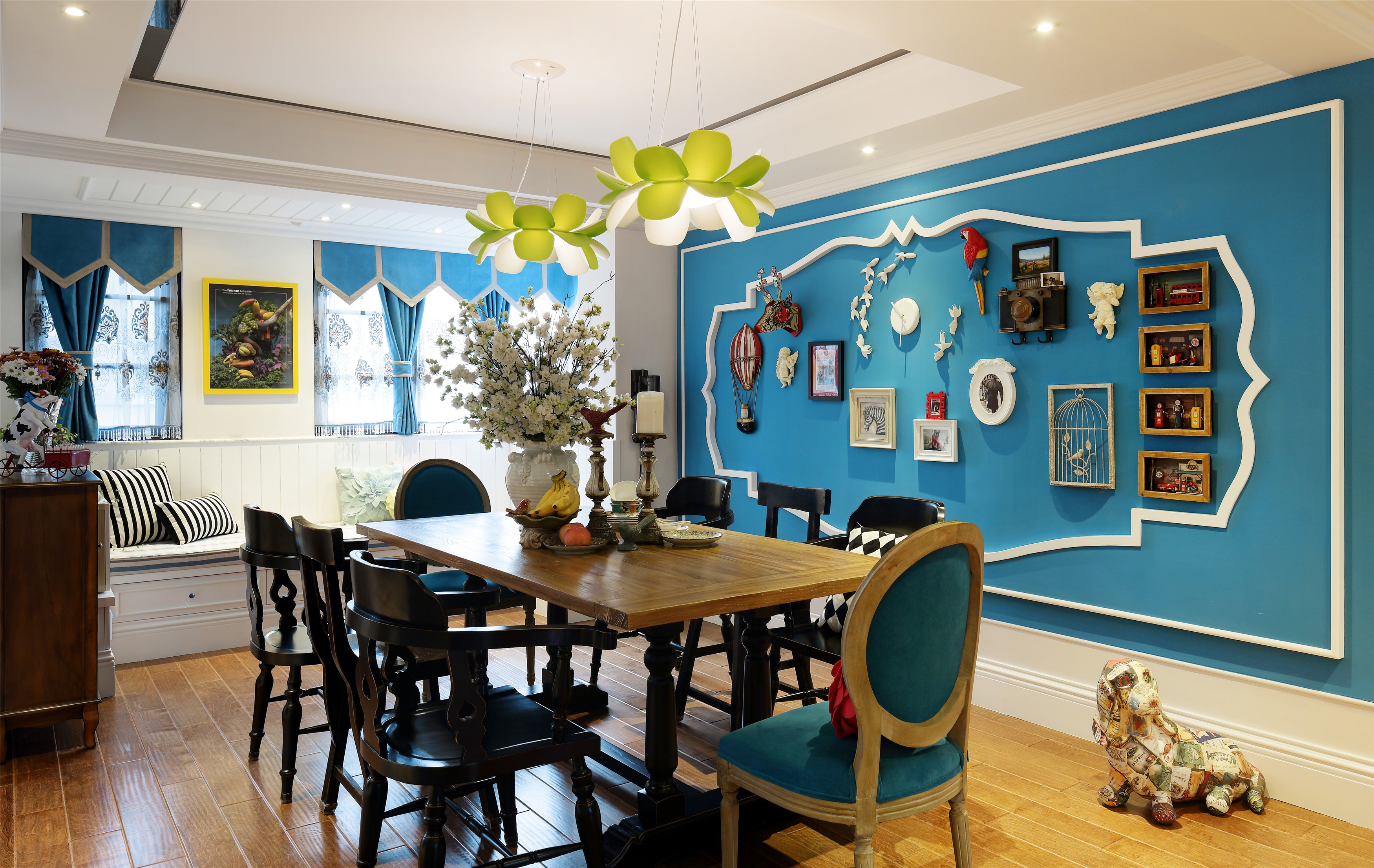 餐厅的区域采用天蓝色作为墙面的颜色点缀，与精美的灯饰搭配，呈现了一种温馨、沉稳和谐的餐桌氛围。