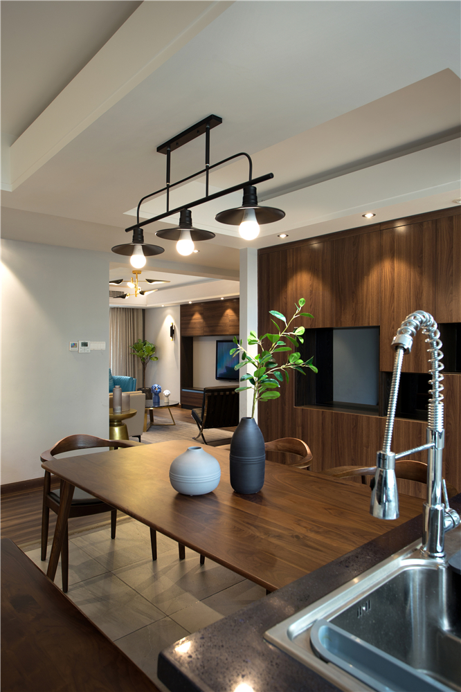 屋主喜欢中式风格，因此餐厅区域采用胡桃木的餐桌和收纳柜，深棕色与白墙搭配，整体既复古又明亮。