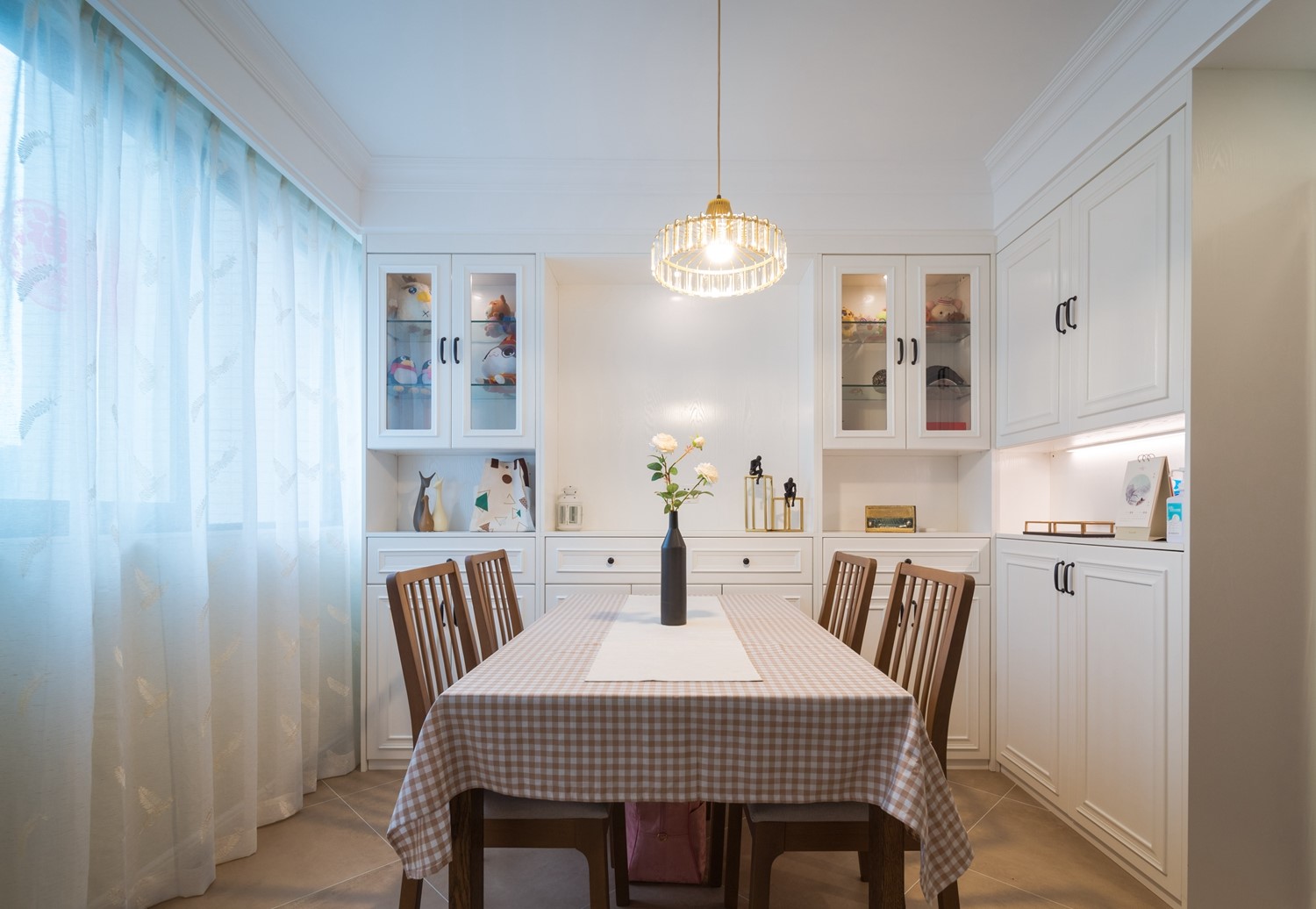 从餐厅看向客厅，窗帘、沙发皆为浅色系，木系材质搭配​白色纱帘，浪漫又有整体感。餐桌椅子的搭配处处显心机，颜色融洽不突兀，简洁有格调。