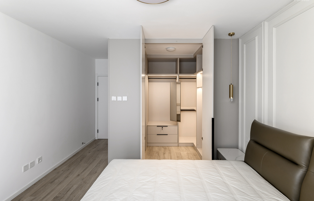 主卧在设计上大面积留白，白色的柜体增强收纳，营造出极简的美感，可以缓解压力，令人放松，安然入睡。