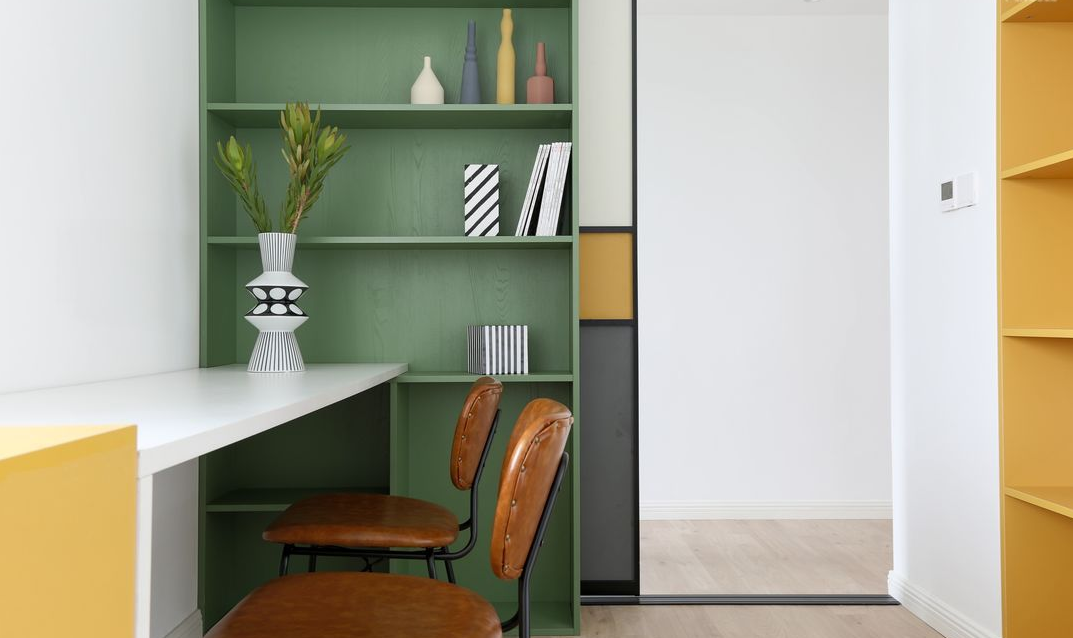 书房采用纯白为主调，靠墙的柜体和分格增强了收纳力，一盆绿植恰当地装饰了空间，更显清新雅致。