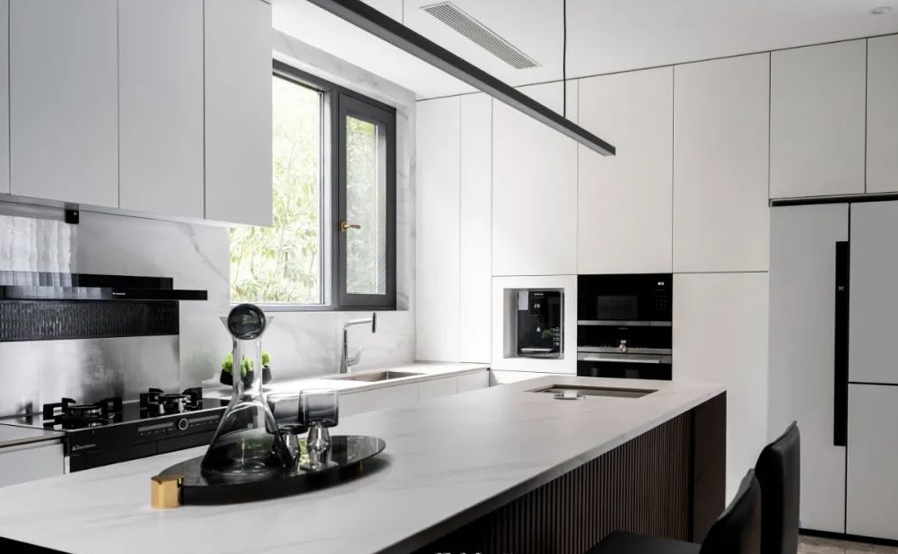 厨房中间采用中岛台设计，中岛台的另一侧是收纳柜放置厨房用品，满足屋主不喜欢多余物件放在桌面的需求。