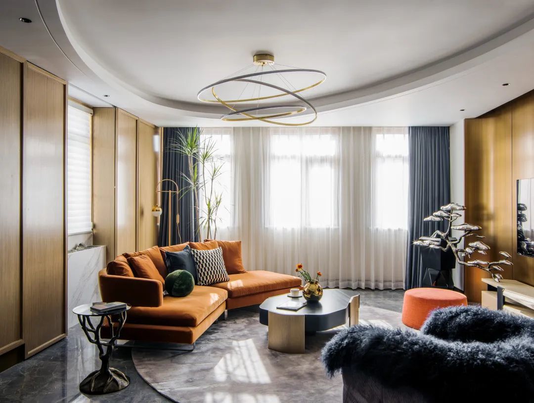 棕色与深蓝搭配的客厅，采用线条感设计，让人感觉既复古又美观独特，镂空的隔墙让功能分区更明显，却又透露出中式美学的神韵。